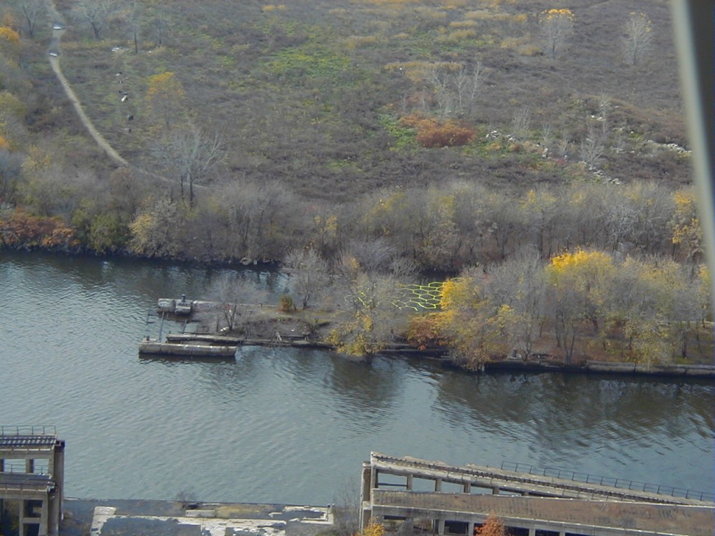 "Aerial photo of river installation—fluorescent patterns cut across polluted Delaware waterway."