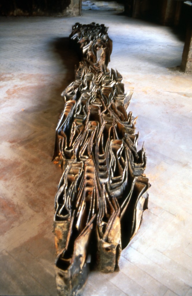 One Day Four Hours: Tug of War installation at Schiffbaubauergasse Potsdam by Edward Dormer, displaying a linear arrangement of burnt books and documents on a wooden floor, representing lost information and historical erasure.